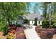 Charming one-story home featuring a lush landscaped yard, mature trees, and a spacious driveway at 11050 Linbrook Ln, Duluth, GA 30097