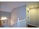 Upstairs hallway with fresh paint, wood floors, and white railing, offering access to rooms at 11050 Linbrook Ln, Duluth, GA 30097
