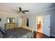Spacious bedroom with a ceiling fan, a dresser, and a view of the ensuite bathroom and walk-in closet at 11050 Linbrook Ln, Duluth, GA 30097