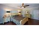 Comfortable main bedroom features hardwood floors, a dresser, two lamps and bedside tables on either side of the bed at 11050 Linbrook Ln, Duluth, GA 30097
