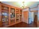 Home office with hardwood floors, built-in shelving, and stylish chandelier lighting at 11050 Linbrook Ln, Duluth, GA 30097