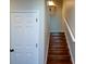 Bright stairway featuring wood steps and white trim, illuminated by a wall sconce at 11050 Linbrook Ln, Duluth, GA 30097