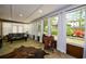 Spacious sunroom features stone floors, a wall of windows, and a vintage saddle for decor at 11050 Linbrook Ln, Duluth, GA 30097