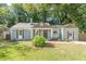Inviting single-story home features neat landscaping and a charming facade with a pop of color at 1404 E Forrest Ave, Atlanta, GA 30344
