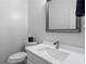 Stylish half bathroom featuring a modern vanity with marble countertop, framed mirror, and toilet for guests at 1438 Sutters Pond Nw Dr, Kennesaw, GA 30152