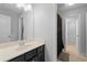 Clean bathroom with a dark vanity, large mirror, and tile flooring at 1438 Sutters Pond Nw Dr, Kennesaw, GA 30152