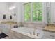 Bathroom featuring double vanity, soaking tub under a window, and a separate shower at 1438 Sutters Pond Nw Dr, Kennesaw, GA 30152