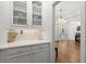 Bright butler's pantry boasts white cabinetry and quartz countertops, with an open view into the home's entry at 1438 Sutters Pond Nw Dr, Kennesaw, GA 30152