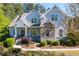 Charming home featuring stone accents, a covered porch, and manicured landscaping at 1438 Sutters Pond Nw Dr, Kennesaw, GA 30152