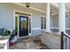 Inviting front porch area featuring stone accents, a black door, and stylish lighting at 1438 Sutters Pond Nw Dr, Kennesaw, GA 30152
