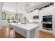 Gourmet kitchen features white cabinetry, stainless steel appliances, an oversized island, and hardwood flooring at 1438 Sutters Pond Nw Dr, Kennesaw, GA 30152