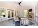 Inviting sunroom with a stone fireplace, ceiling fan, neutral furniture, and views of the wooded lot at 1438 Sutters Pond Nw Dr, Kennesaw, GA 30152