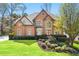 Charming brick home featuring a lush green lawn and manicured landscaping at 317 Vista Lake Dr, Suwanee, GA 30024