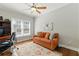 Comfortable home office with hardwood floors, a large window, and a cozy orange sofa at 317 Vista Lake Dr, Suwanee, GA 30024