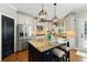 Modern kitchen with a granite island, stainless steel appliances, and elegant light fixtures at 317 Vista Lake Dr, Suwanee, GA 30024