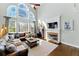 Bright living room boasts soaring windows, a brick fireplace, and a comfortable, oversized leather sectional at 317 Vista Lake Dr, Suwanee, GA 30024