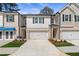 Charming townhome featuring a brick and siding facade, two-car garage, and well-manicured landscaping at 413 Brooch Way, Stockbridge, GA 30281