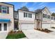 Charming townhome featuring a brick and siding facade, two-car garage, and well-manicured landscaping at 413 Brooch Way, Stockbridge, GA 30281