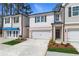 Charming townhome featuring a brick and siding facade, two-car garage, and well-manicured landscaping at 413 Brooch Way, Stockbridge, GA 30281
