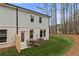 Two-story home with gray siding and brick foundation, backyard and table with chairs at 425 Brooch Way, Stockbridge, GA 30281