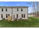 Two-story home with gray siding and brick foundation, backyard and table with chairs at 425 Brooch Way, Stockbridge, GA 30281