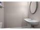 Elegant powder room features a pedestal sink, stylish mirror, and neutral color palette for a clean look at 1123 Providence Pl, Decatur, GA 30033