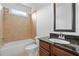 Full bathroom features a granite-topped vanity, shower-tub combo and tile, offering a cozy design at 2365 Barrington Trace Sw Cir, Atlanta, GA 30331