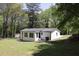 Exterior shot of a white home with a large backyard and mature trees at 3811 Crosby Nw Dr, Atlanta, GA 30331