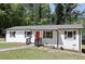 Inviting single-story home showcasing a vibrant red front door, complimented by a neat landscape at 3811 Crosby Nw Dr, Atlanta, GA 30331