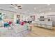 Bright, open-concept living room with hardwood floors, modern furniture, and lots of natural light at 417 Brooch Way, Stockbridge, GA 30281