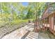 Backyard patio featuring stone pavers, lush greenery, and a wooden deck perfect for relaxation and outdoor living at 951 Woodmont Dr, Marietta, GA 30062