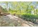 Stone patio with lush greenery and mature trees offering a private and serene outdoor space at 951 Woodmont Dr, Marietta, GA 30062