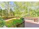 Landscaped backyard with a wooden deck, lush lawn, and mature trees providing shade and privacy at 951 Woodmont Dr, Marietta, GA 30062
