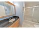 Bathroom with tile floor and shower, black countertop and mirror at 951 Woodmont Dr, Marietta, GA 30062