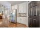 Butler's pantry with white cabinets, granite counters and stainless steel refrigerator at 18 Crolley Ln, White, GA 30184