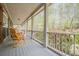 Covered front porch with rocking chairs overlooking wooded yard and blossoming trees at 18 Crolley Ln, White, GA 30184