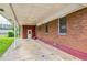 Spacious covered back porch extending along brick house, ideal for outdoor relaxation and entertaining at 5295 Woodland Dr, Lake City, GA 30260