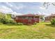 View of the rear exterior of home and screened porch with stairs leading down to the yard at 5295 Woodland Dr, Lake City, GA 30260