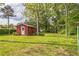Large grassy yard featuring a detached storage building, providing ample outdoor space at 5295 Woodland Dr, Lake City, GA 30260