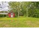 Expansive backyard with a red shed, perfect for outdoor activities and storage at 5295 Woodland Dr, Lake City, GA 30260