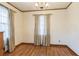 Dining room featuring hardwood floors, large windows with curtains, and traditional trim and finishes at 5295 Woodland Dr, Lake City, GA 30260