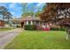 Attractive brick home with vibrant red stairs, manicured lawn and mature landscaping at 5295 Woodland Dr, Lake City, GA 30260