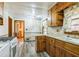Kitchen featuring vintage wood cabinets, laminate countertops, updated flooring, and a window above the sink at 5295 Woodland Dr, Lake City, GA 30260