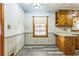 Bright kitchen with wood cabinets, a window, and light gray flooring at 5295 Woodland Dr, Lake City, GA 30260