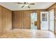 Living room with vertical wood paneled walls, a ceiling fan, and a door leading to the outside at 5295 Woodland Dr, Lake City, GA 30260