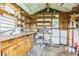 Messy shed with wood shelves, a workbench, and a dirty floor at 5295 Woodland Dr, Lake City, GA 30260