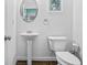 Chic powder room featuring a pedestal sink, a modern toilet, and stylish decor at 7691 Cabrini Pl, Fairburn, GA 30213