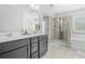Bathroom featuring double sinks, a glass-enclosed shower, and a soaking tub at 7691 Cabrini Pl, Fairburn, GA 30213