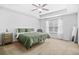 Bright bedroom with neutral carpet, a ceiling fan, and a window providing natural light at 7691 Cabrini Pl, Fairburn, GA 30213