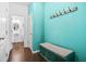 Inviting entryway with blue accent wall, coat hooks, and a storage bench with cushion at 7691 Cabrini Pl, Fairburn, GA 30213